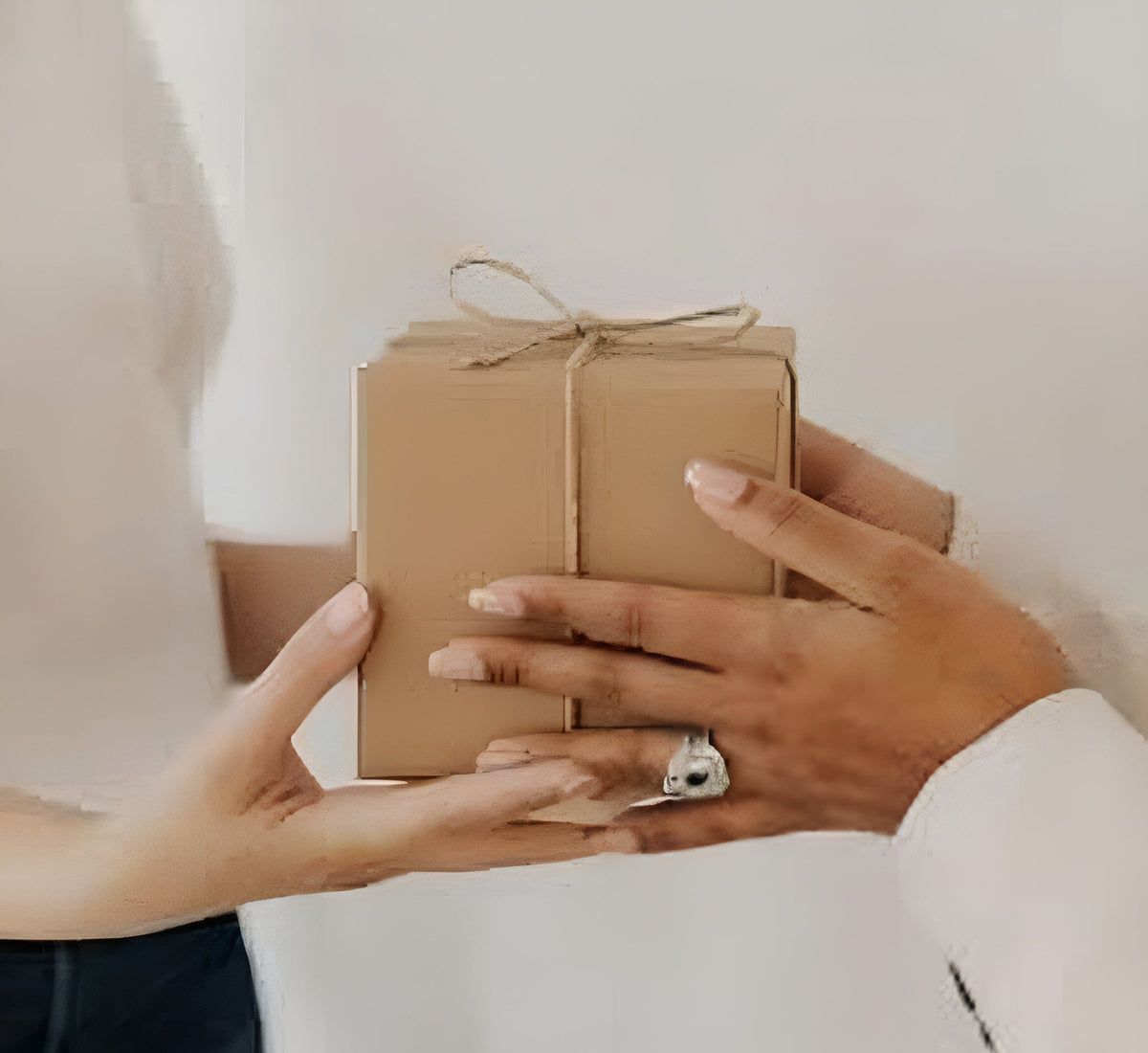 Two people exchanging a Signature Wick Co gift box, highlighting the premium packaging of our goldfish gel candle